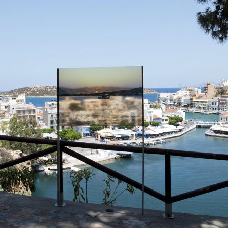 Με θέα στη θάλασσα, 2018 (άποψη μέρους της εγκατάστασης), από την έκθεση στο δημόσιο χώρο «Το Πνεύμα της Σκάλας» σε επιμέλεια Θεόφιλου Τραμπούλη-Ελένης Κούκου Πέντε εικόνες τυπωμένες σε ημιδιαφανές πλεξιγκλάς και τοποθετημένες στις σκάλες της λίμνης του Αγίου Νικολάου (Λασιθίου Κρήτης). Διαστάσεις διάφορες.